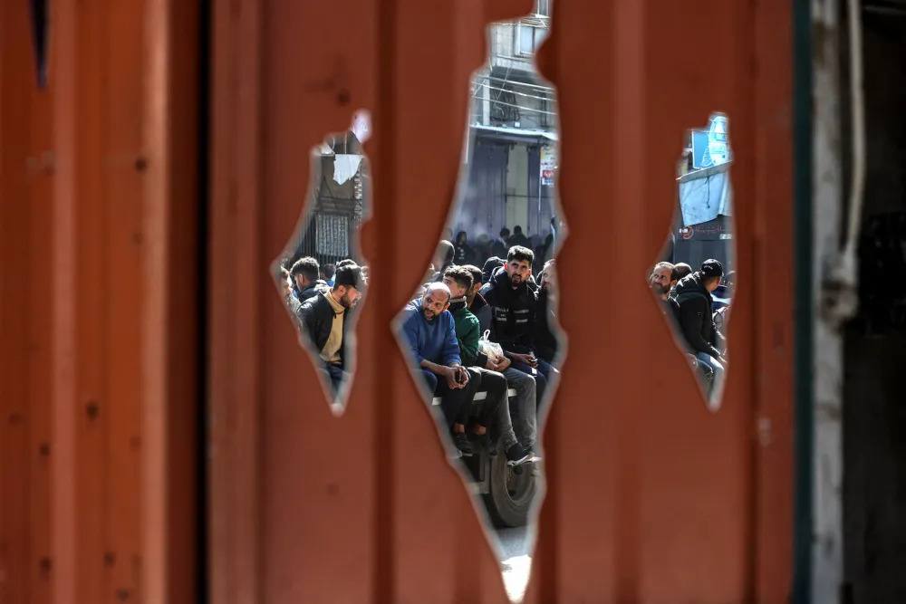Palestinians riding on a cart are refected on a mirror in the shape of the map of Palestine in Rafah, on the southern Gaza Strip on February 7, 2024 amid ongoing battles between Israel and the militant Hamas group.