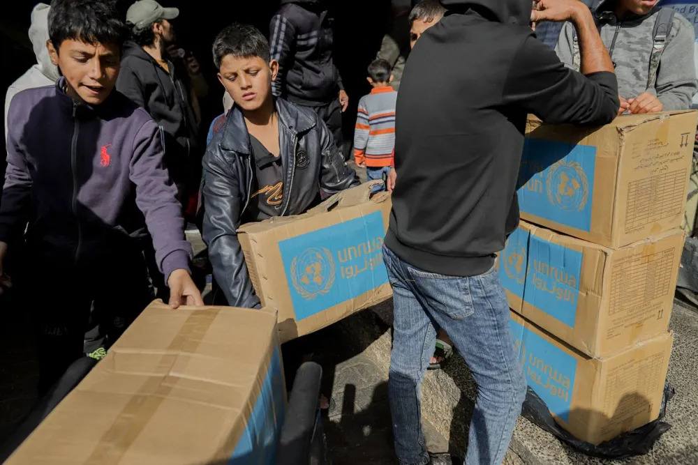 Residents gather around a delivery of aid boxes in Deir al-Balah in Gaza on Jan. 23.